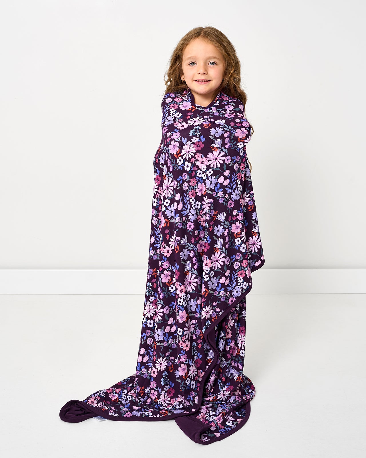 Standing girl wrapped int the Violet Meadow Large Cloud Blanket®