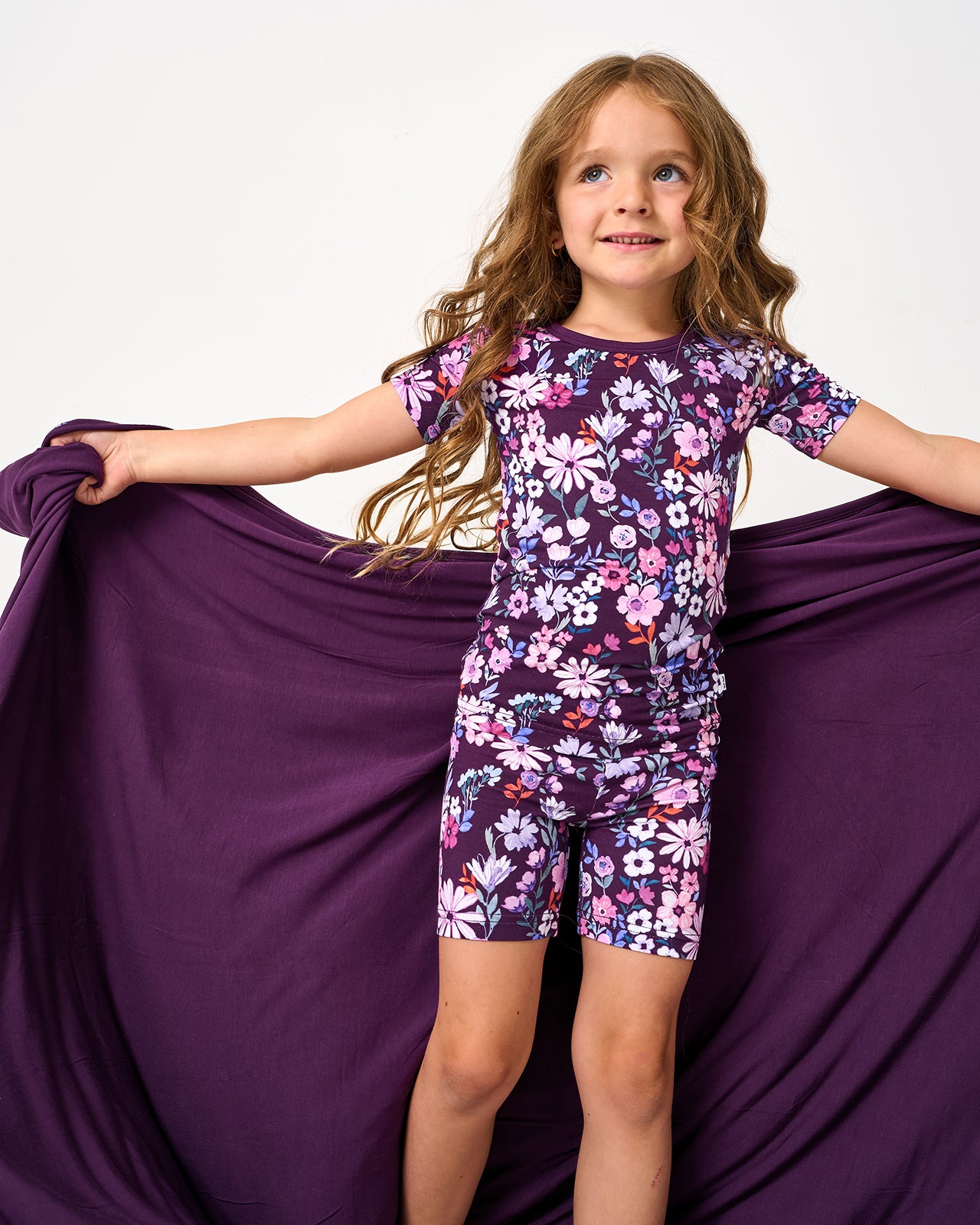 Girl holding up the Violet Meadow Large Cloud Blanket®