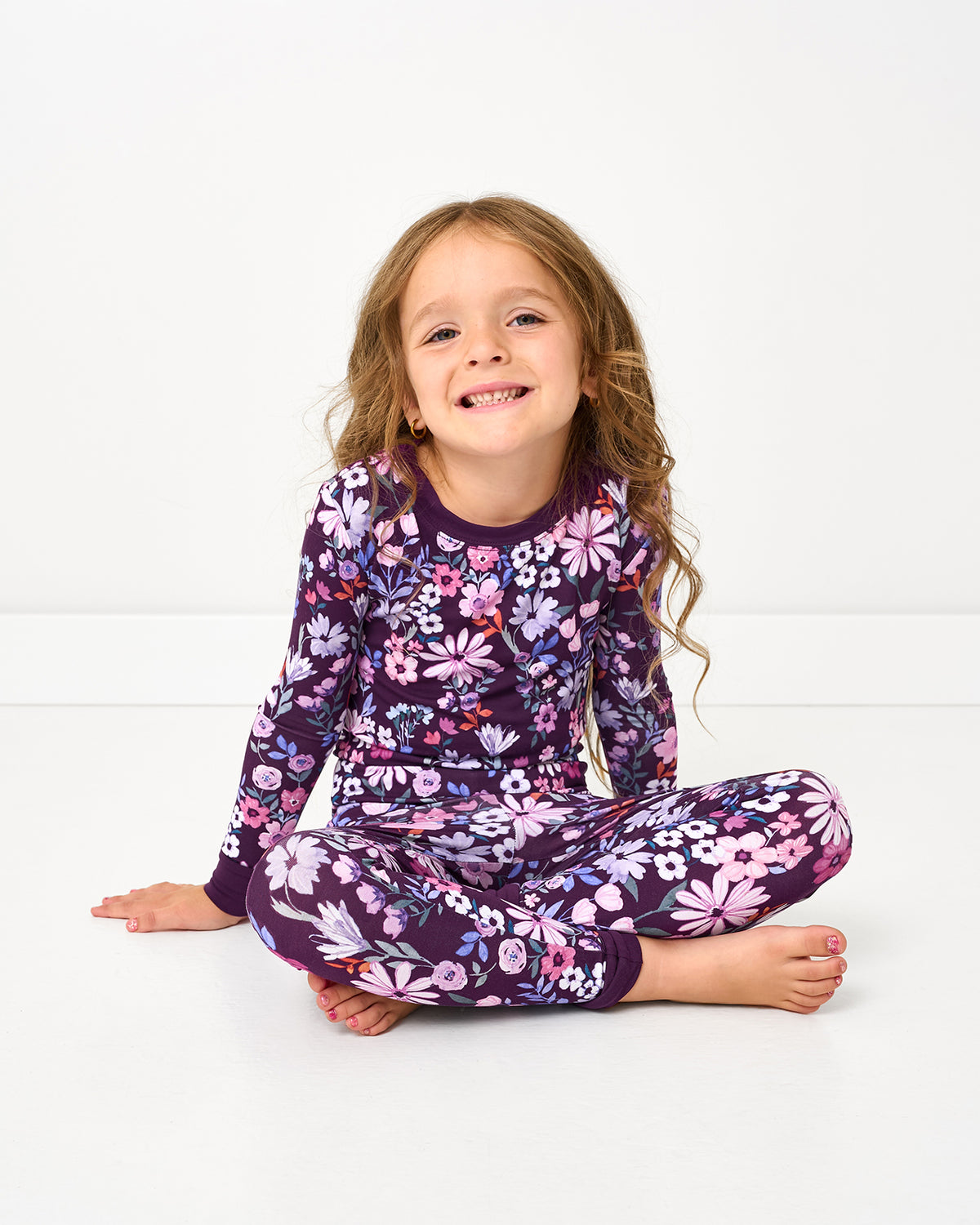 Sitting girl wearing the Violet Meadow Two-Piece Pajama Set