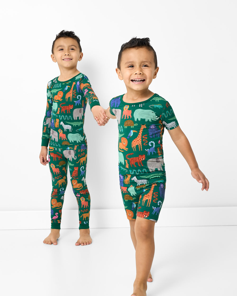 Two children holding hands wearing matching Wild Zoo Two-Piece Pajama Sets