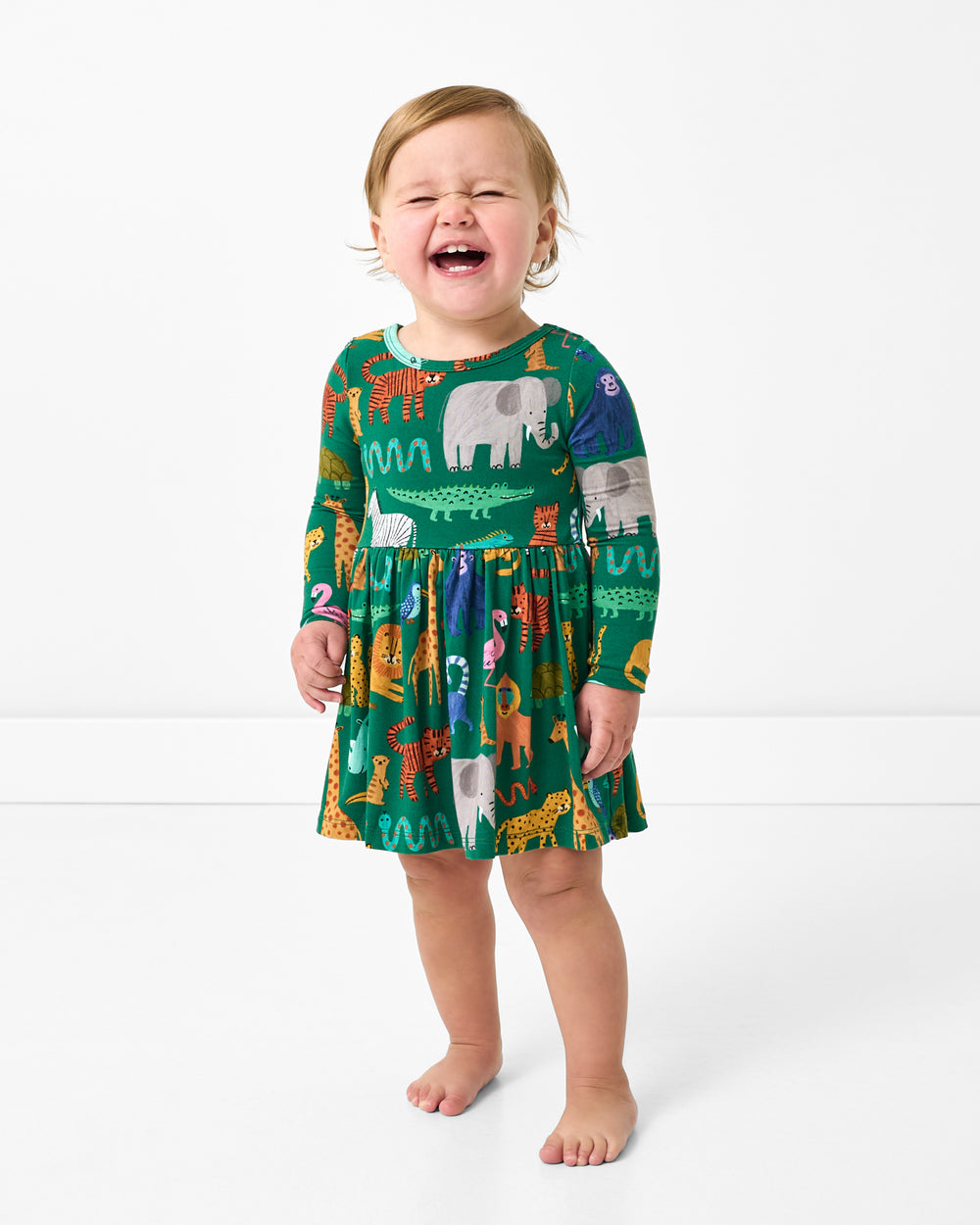Standing toddler wearing the Wild Zoo Skater Dress with Bodysuit