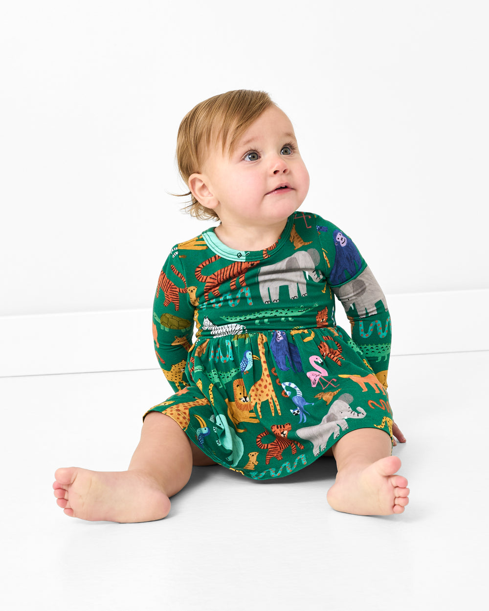 Sitting baby wearing the Wild Zoo Skater Dress with Bodysuit
