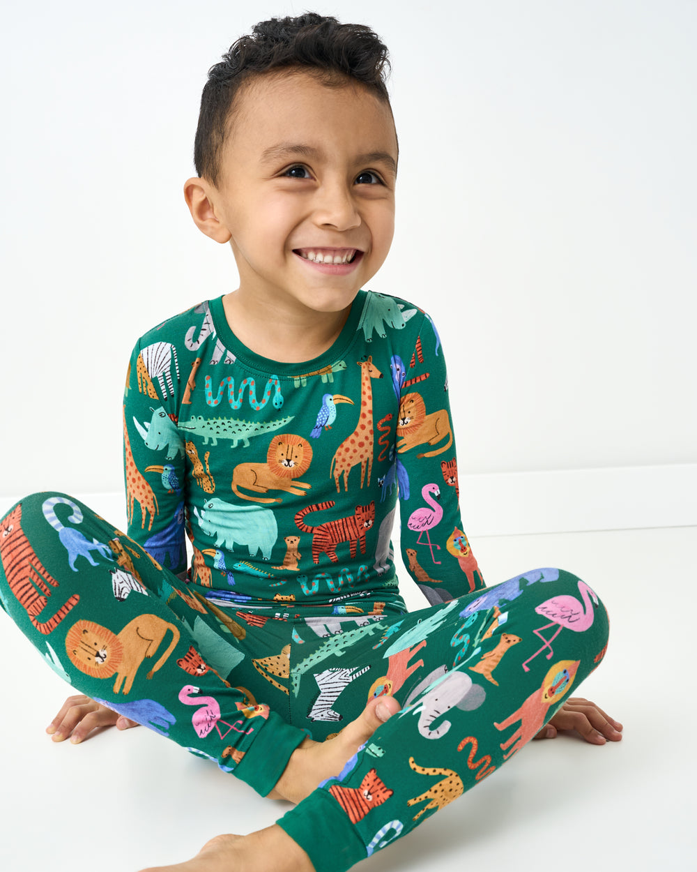 Sitting boy wearing the Wild Zoo Two-Piece Pajama Set