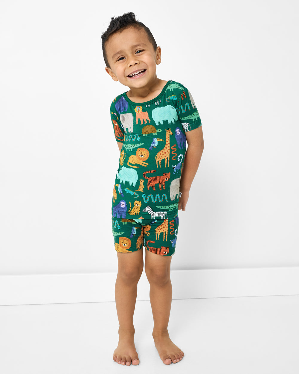 Standing boy wearing the Wild Zoo Two-Piece Short Sleeve & Shorts Pajama Set