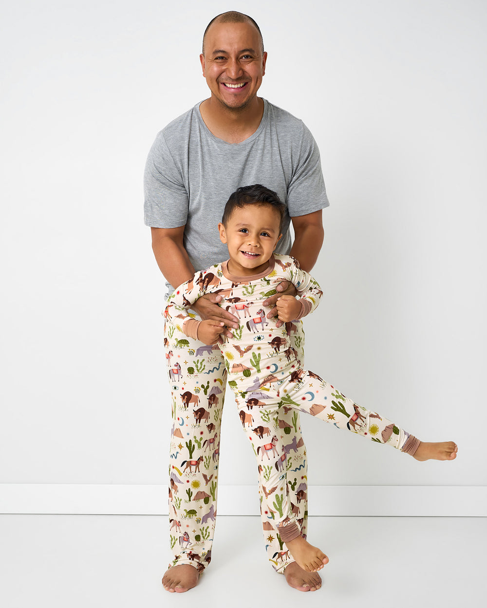 Father and son standing together wearing matching Wild Frontier pajamas