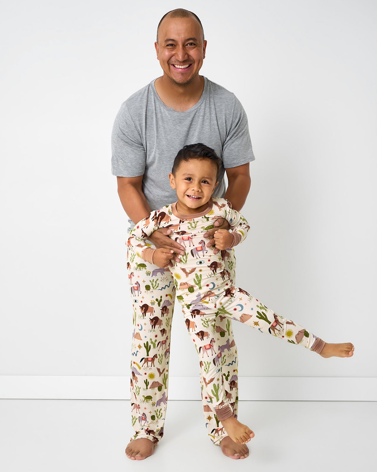 Father and son standing together wearing matching Wild Frontier pajamas