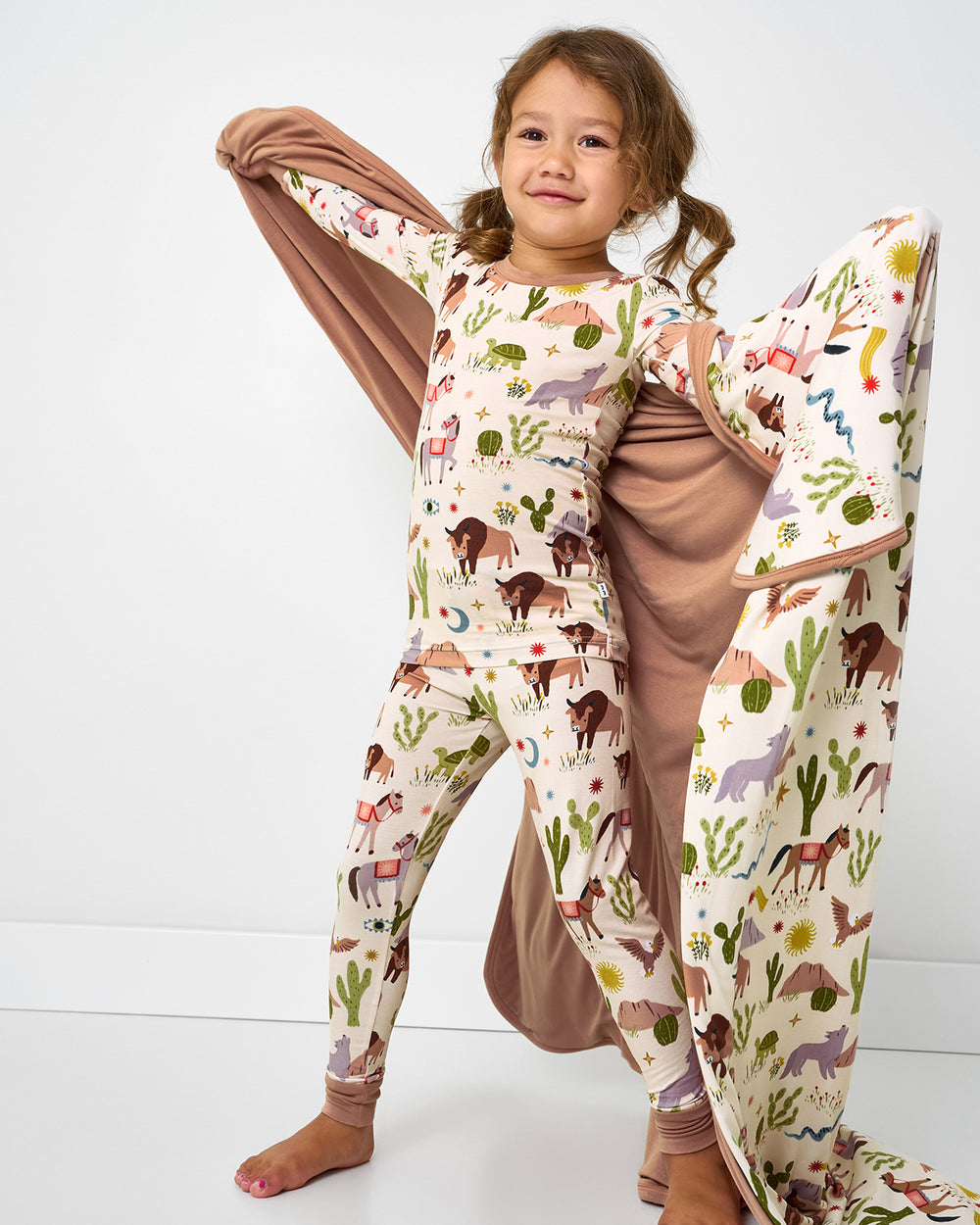 Child holding up the Wild Frontier Large Cloud Blanket®