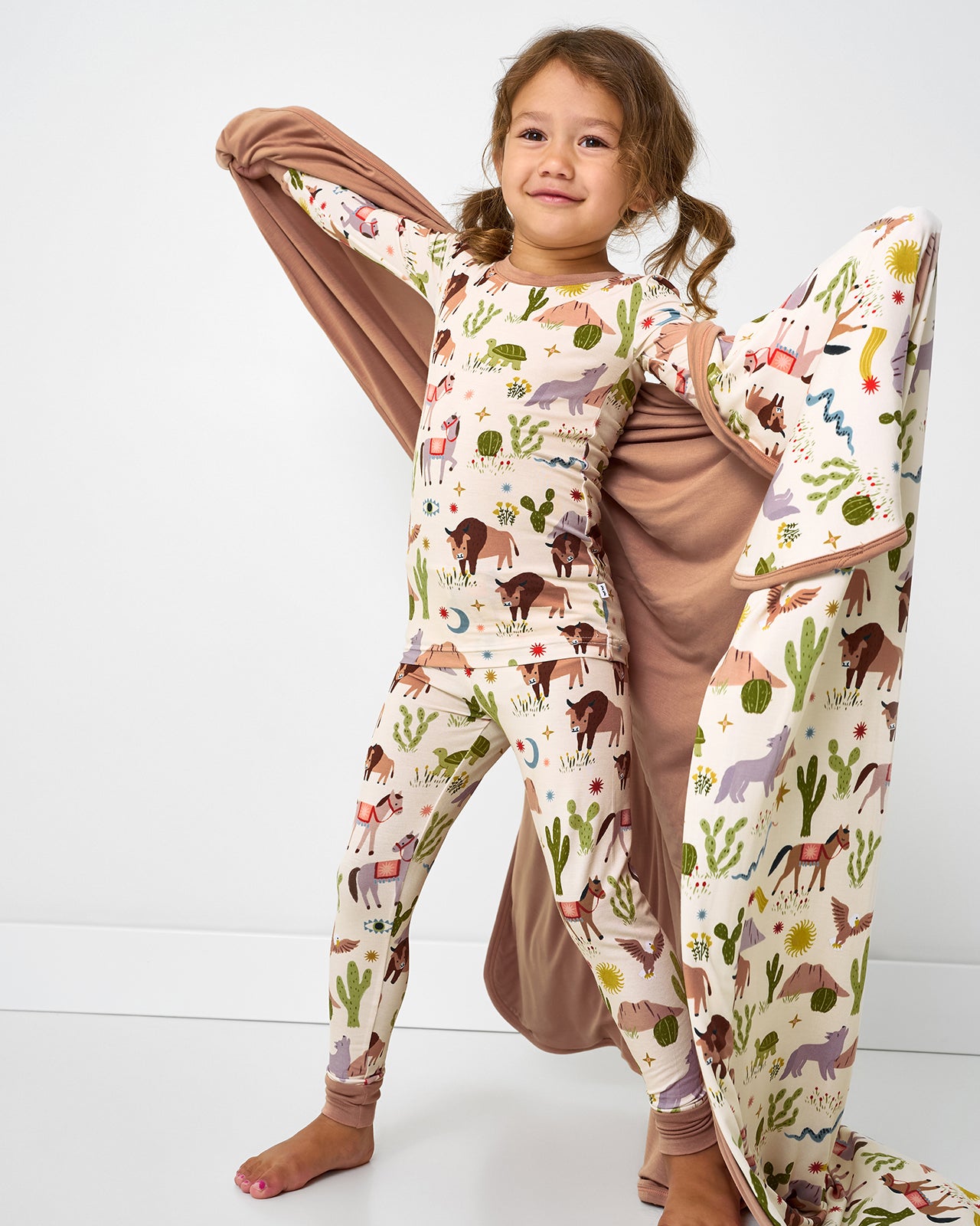 Child holding up the Wild Frontier Large Cloud Blanket®