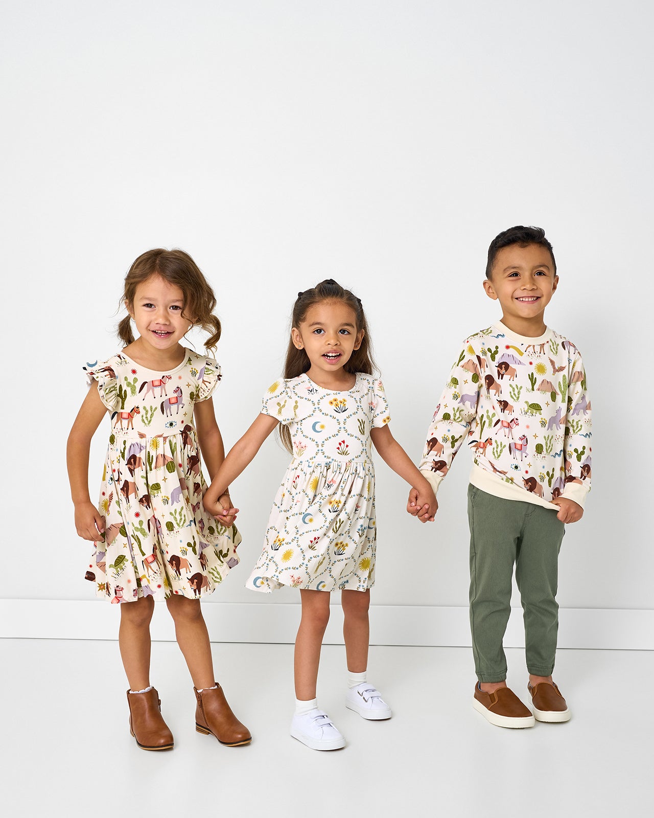 Three children wearing styles from the Wild Frontier and Desert Meadow collections