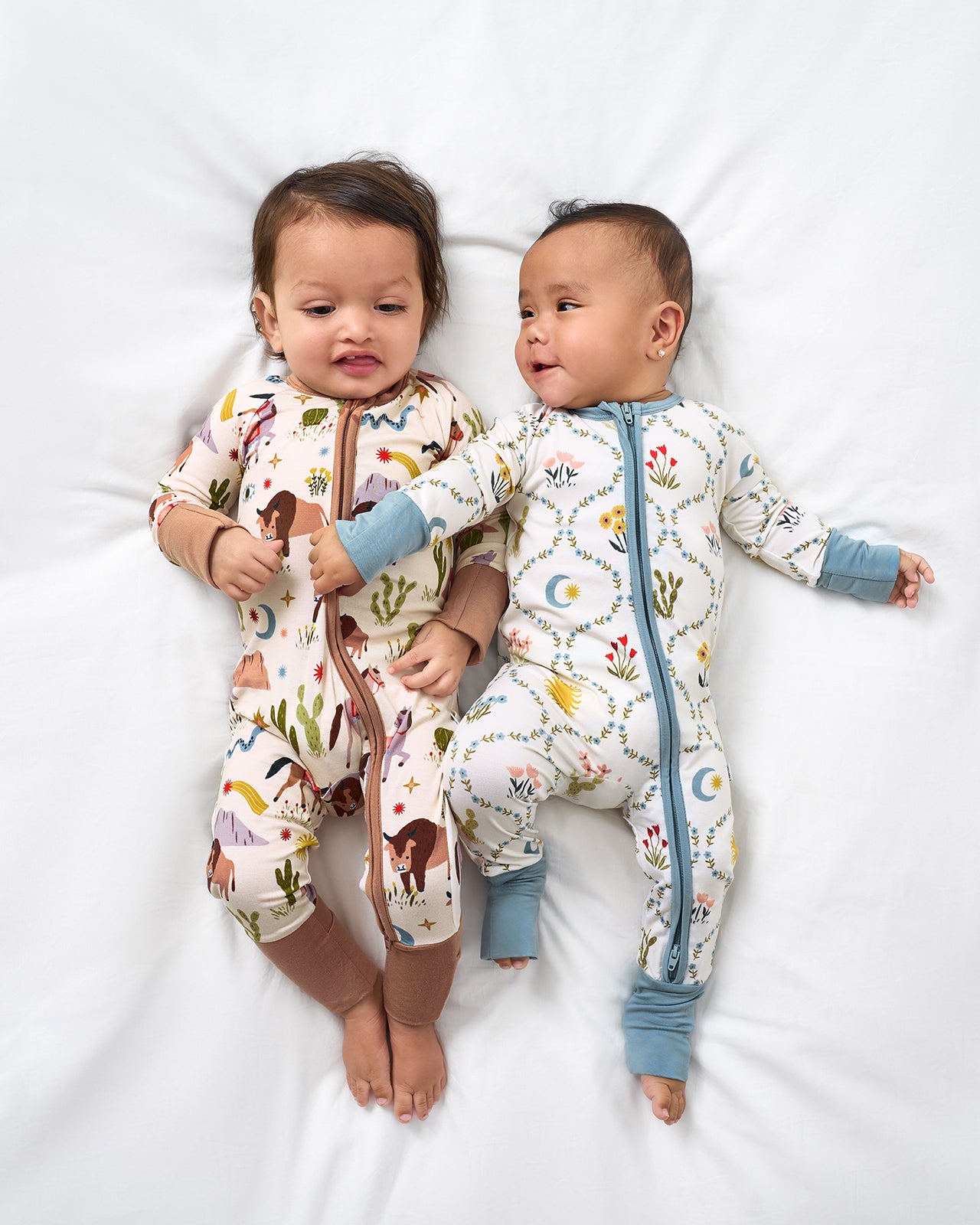 Two babies wearing Wild Frontier and Desert Meadow zippies 