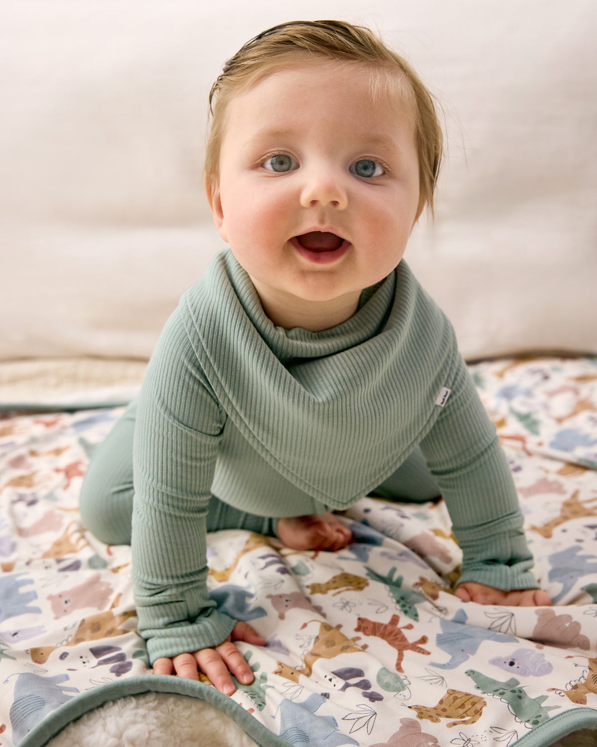 Crawling newborn wearing the Willow Baby Ribbed Bandana Bib