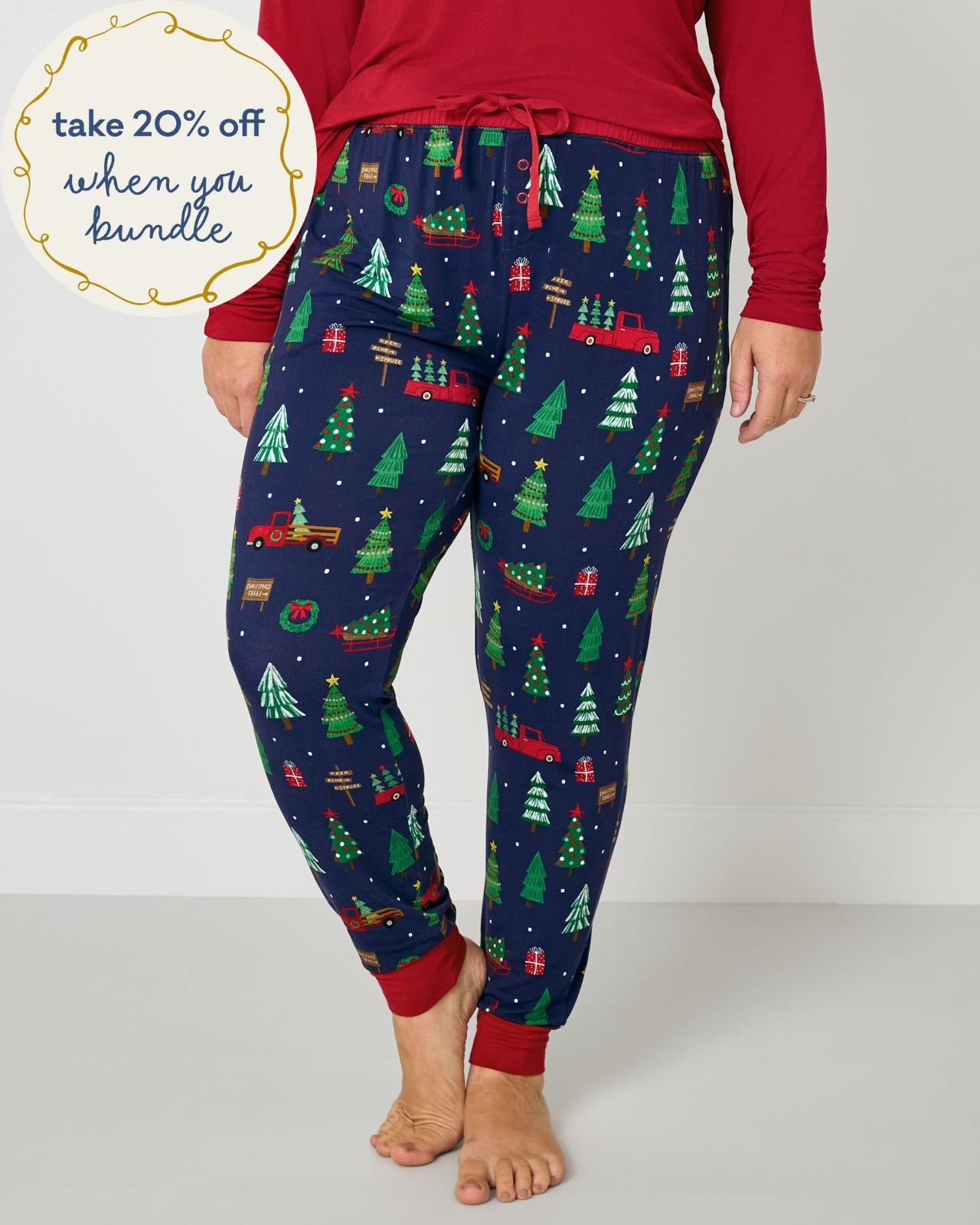 Woman wearing the Navy Tree Traffic Women's Pajama Pants with a holiday red pajama top