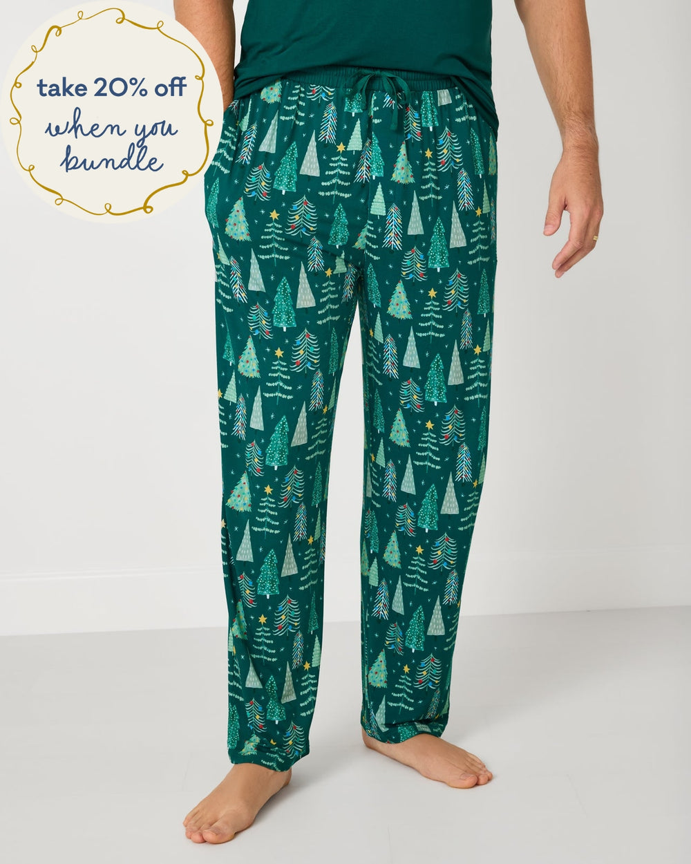 Man wearing the Twinkling Trees Men's Pajama Pants with a green pajama top
