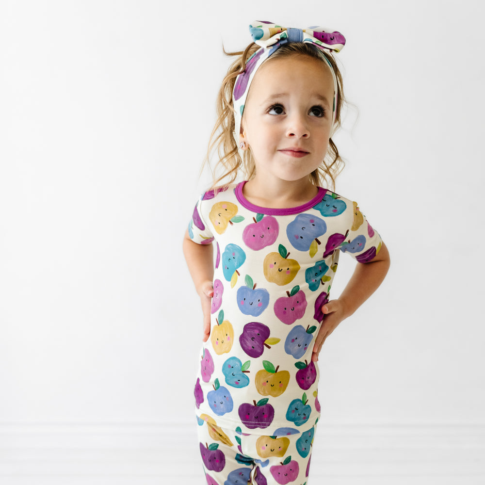 Alternate image of a child wearing a Berry Apple of my Eye two piece short sleeve pajama set and matching luxe bow headband