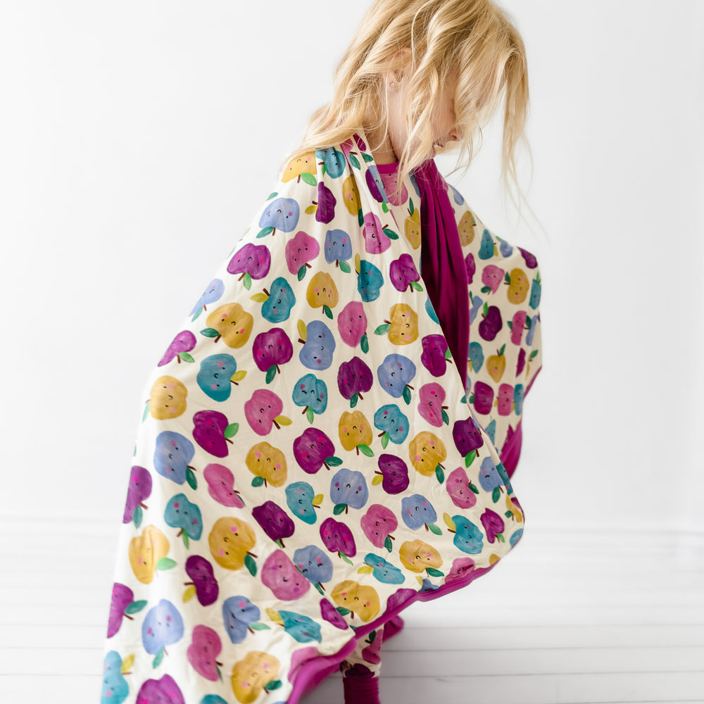 Side view image of a child wrapped up in a Berry Apple of my Eye large cloud blanket
