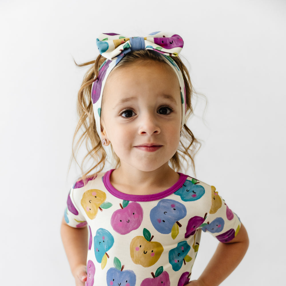 Click to see full screen - Child wearing a Berry Apple of my Eye luxe bow headband and matching short sleeve pajamas