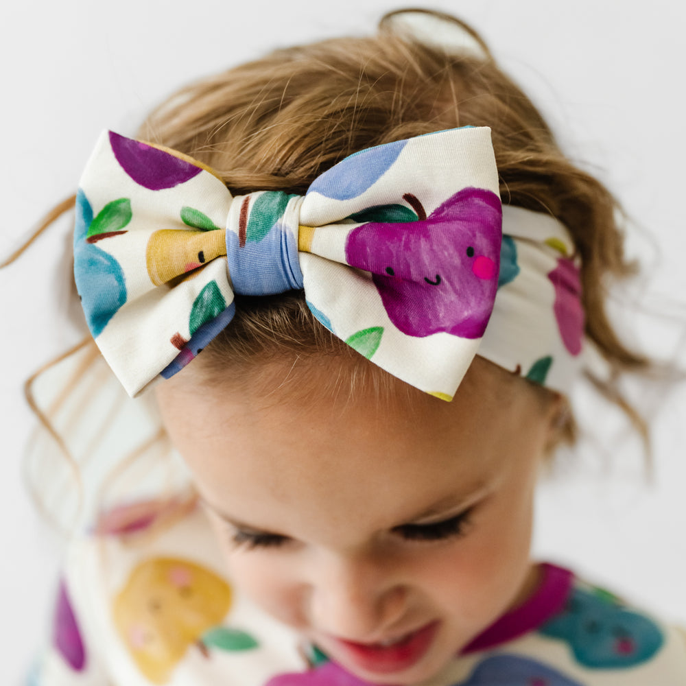 Click to see full screen - Close up image of a child wearing a Berry Apple of my Eye luxe bow headband