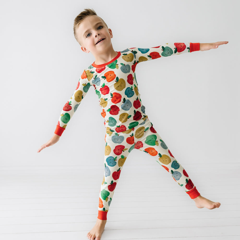 Child standing on one foot wearing a Red Apple of My Eye two piece pajama set