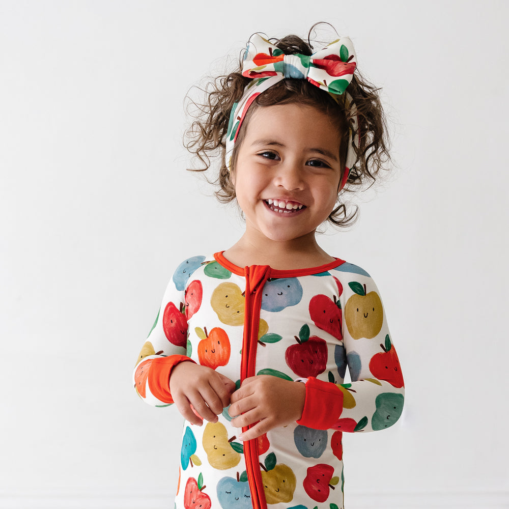 Alternate image of a child wearing a Red Apple of My Eye luxe bow headband and matching pajamas