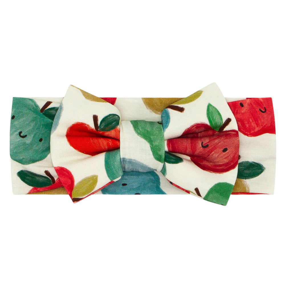 Flat lay image of a Red Apple of My Eye luxe bow headband