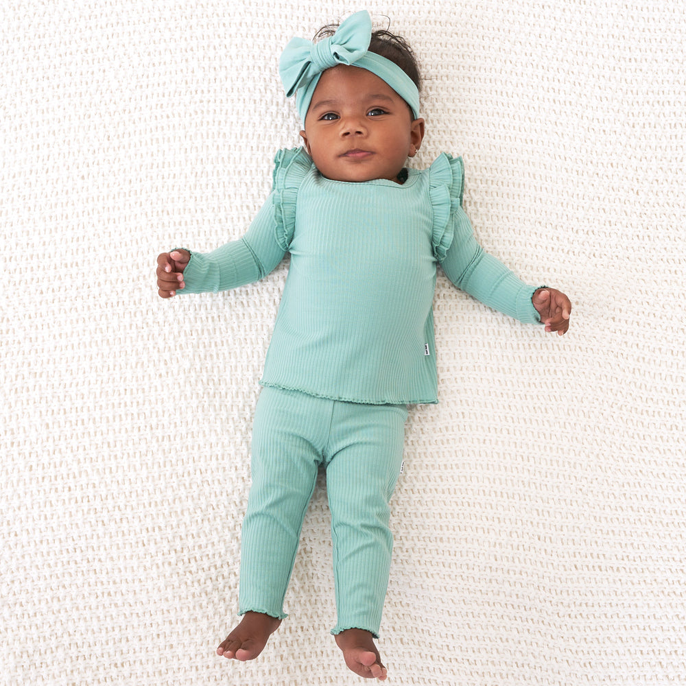 Child wearing a Aqua Mist Ribbed Flutter Lettuce Tee paired with matching leggings and luxe bow headband