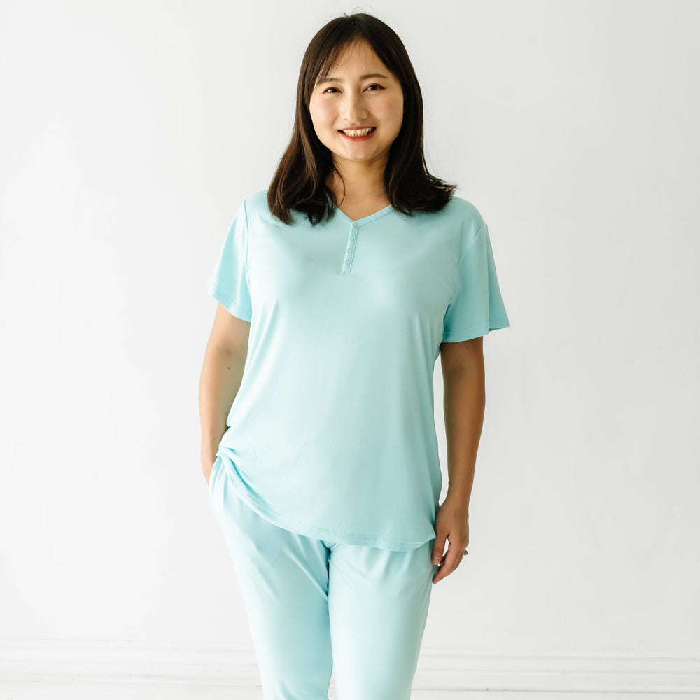 Woman wearing an Aquamarine women's short sleeve pajama top paired with women's Aquamarine pajama pants
