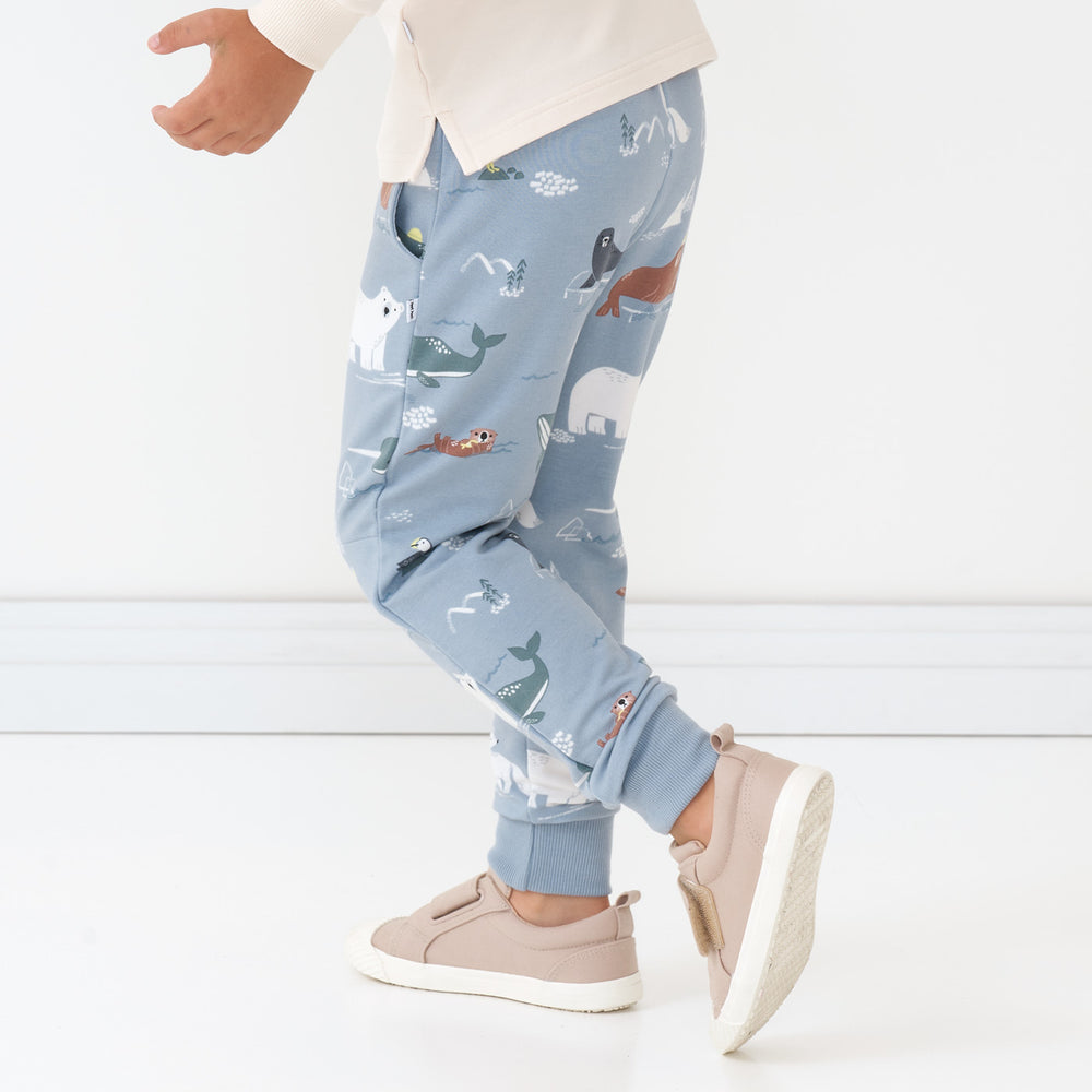 Close up side view image of a child wearing Arctic Animals printed joggers