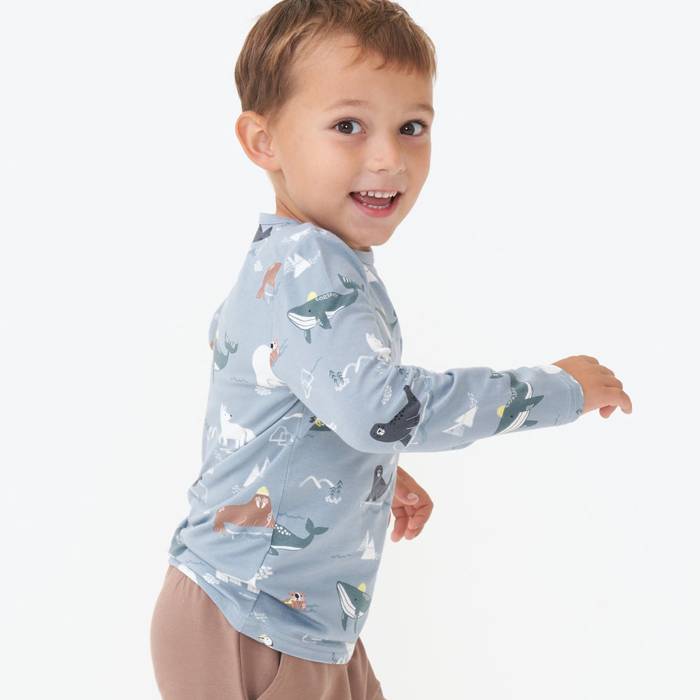 Alternate close up side view image of a child wearing an Arctic Animals printed pocket tee and coordinating joggers