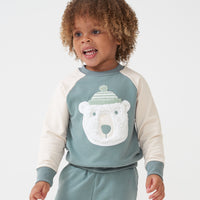 Child looking to the side wearing a Polar Bear crewneck sweatshirt