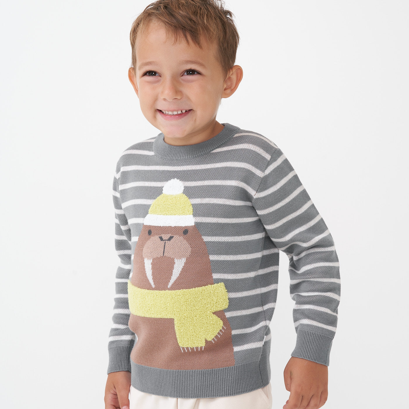 Child laughing wearing a Walrus knit sweater