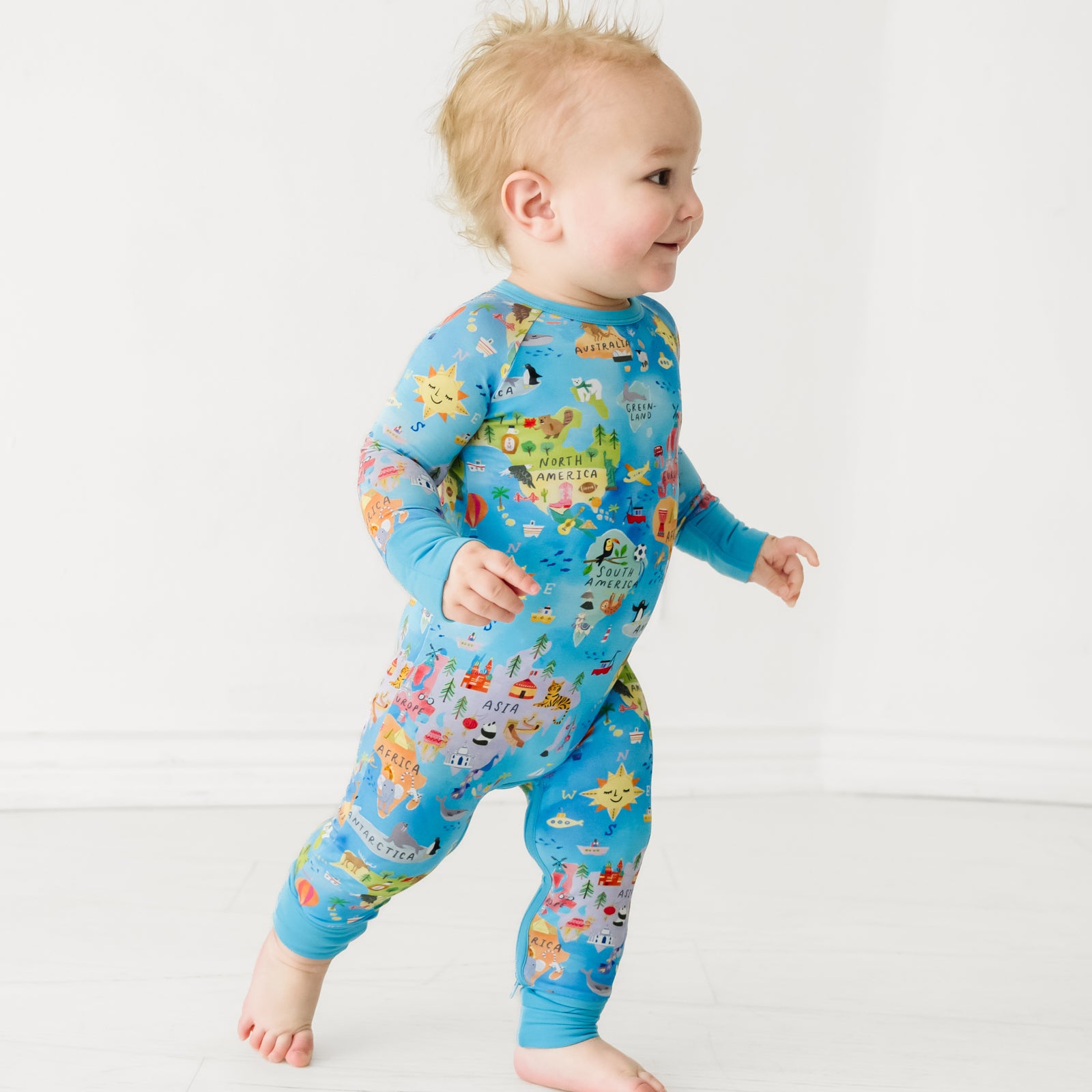 Child walking to the right, wearing an Around the World Crescent Zippy