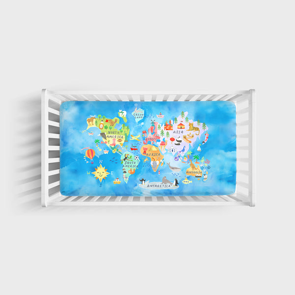 Aerial view of an Around the World bamboo fitted crib sheet on a mattress in a crib