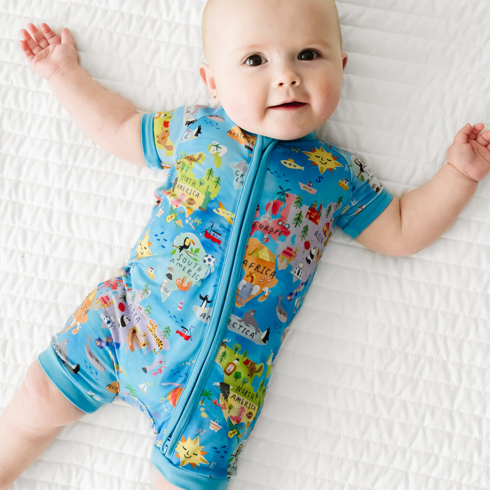 Close up view of a child lying on a bed wearing an Around the World Shorty Zippy