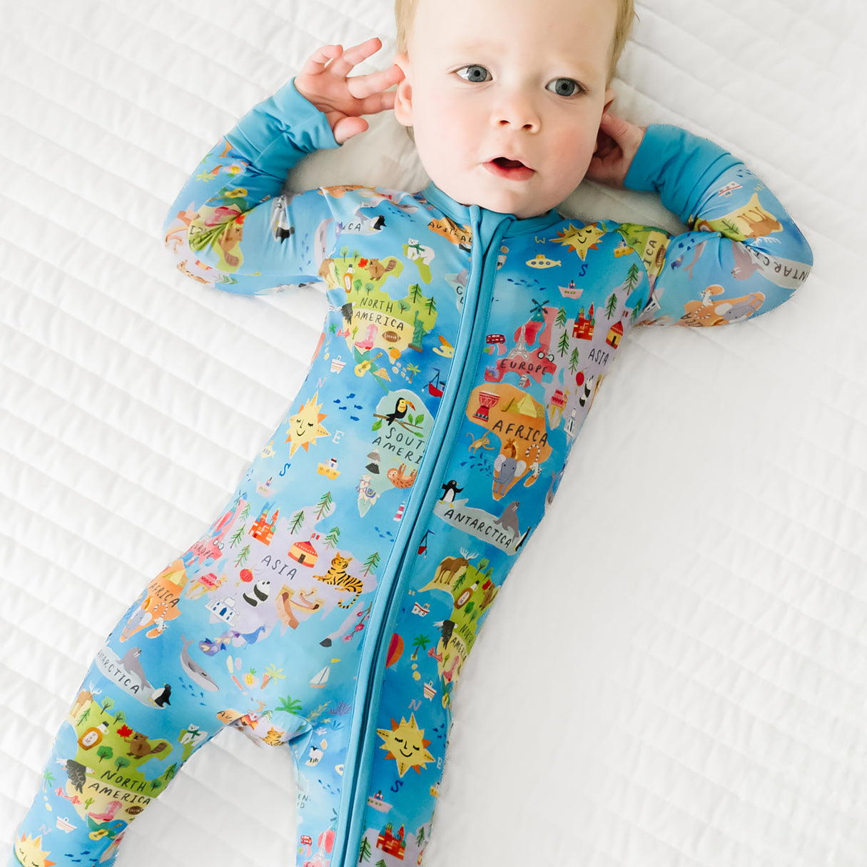 Close up view of a child lying down wearing an Around the World Zippy