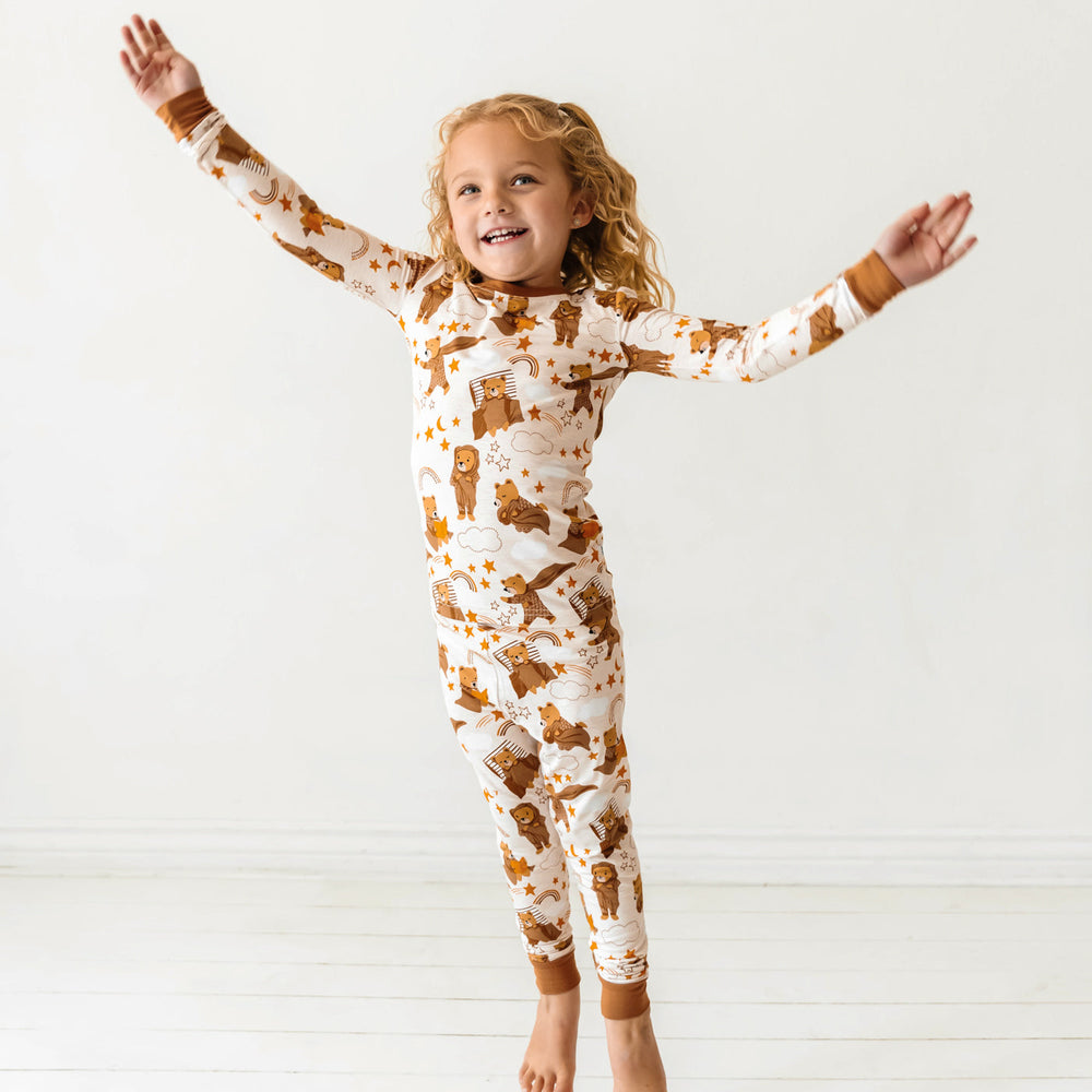 Jumping child wearing a Beary Sleepy Two-Piece Pajama Set