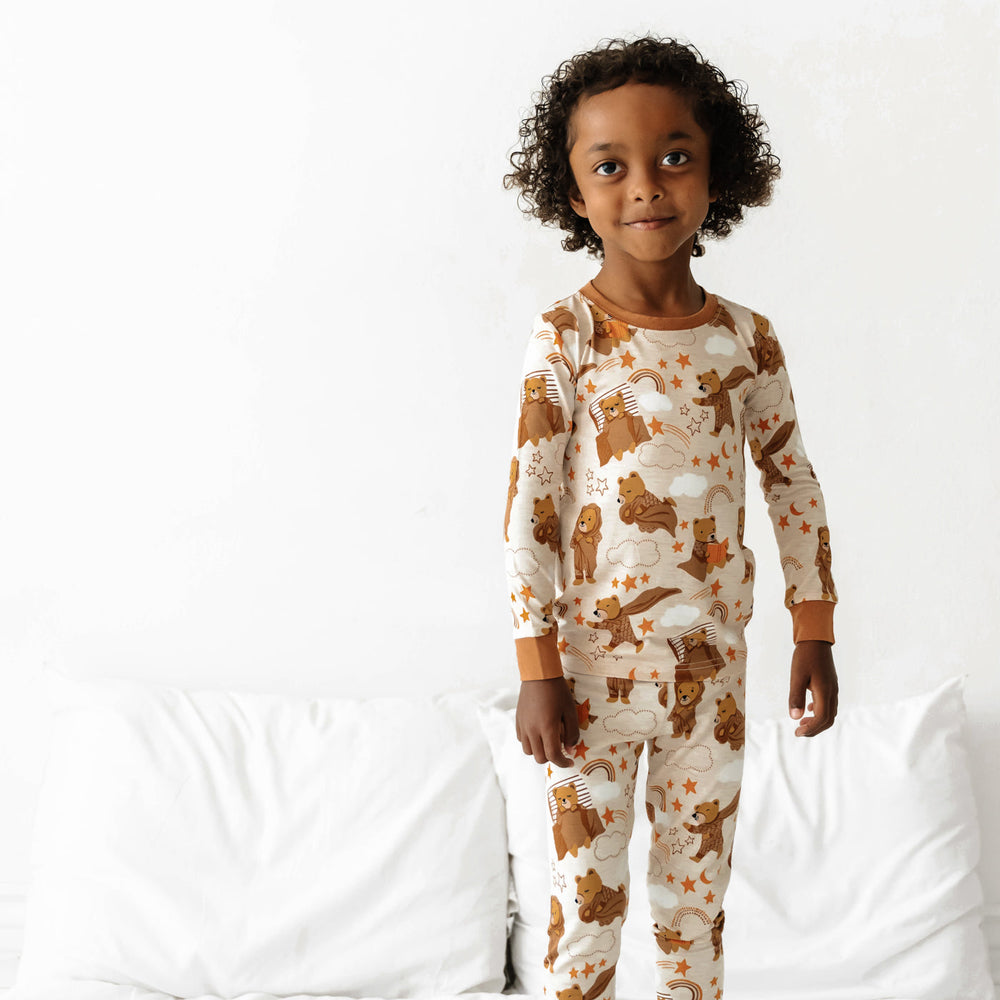 Child standing on a bed wearing a Beary Sleepy Two-Piece Pajama Set