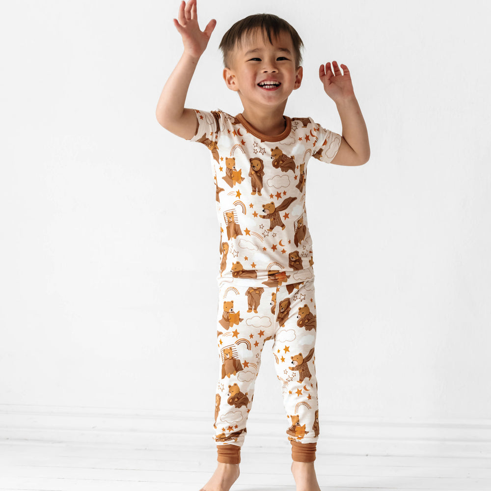 Child jumping and wearing a Beary Sleepy Two-Piece Short Sleeve Pajama Set