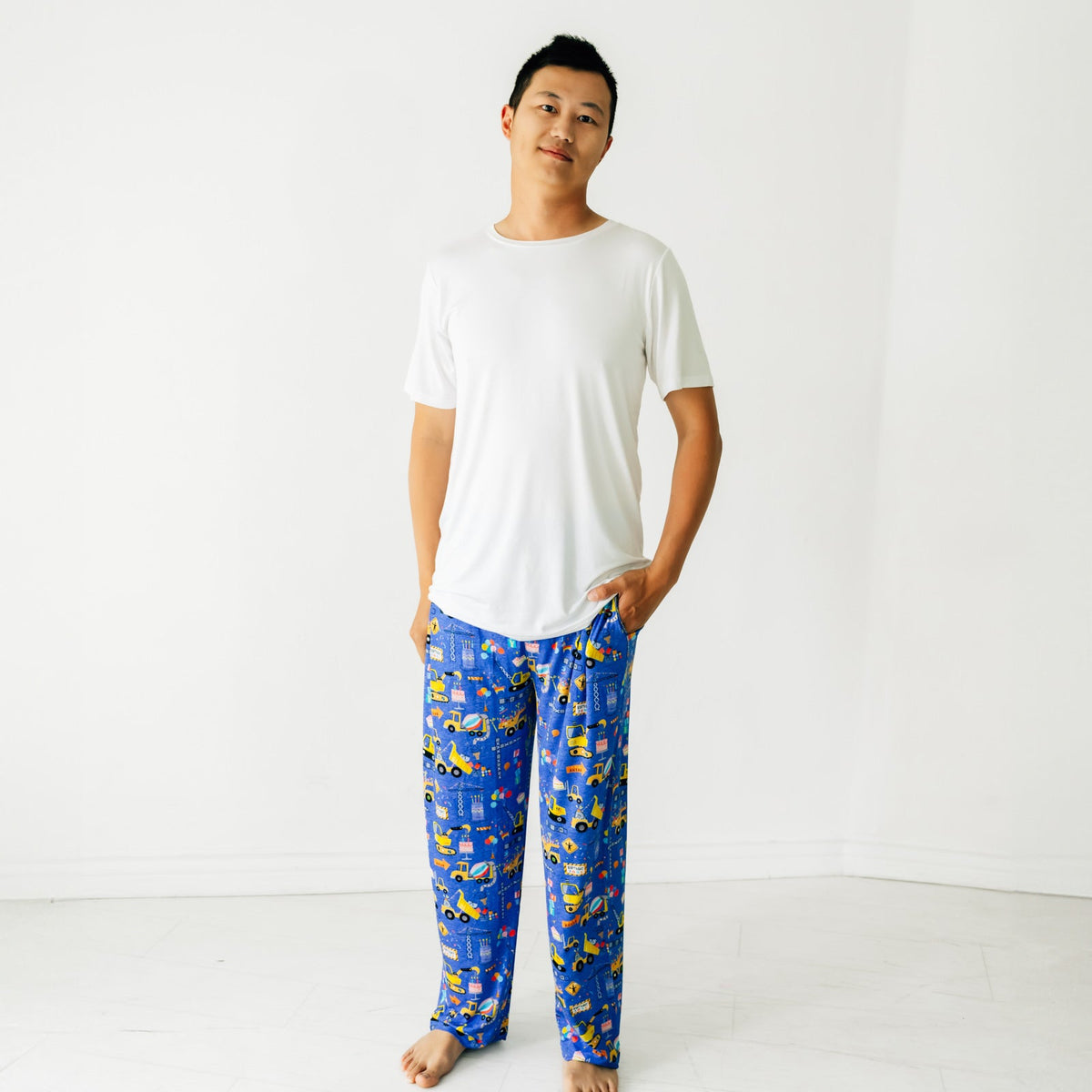 Man standing with a hand in his pocket wearing Birthday Builders Men's Pajama Pants and a Bright White Men's Pajama Top
