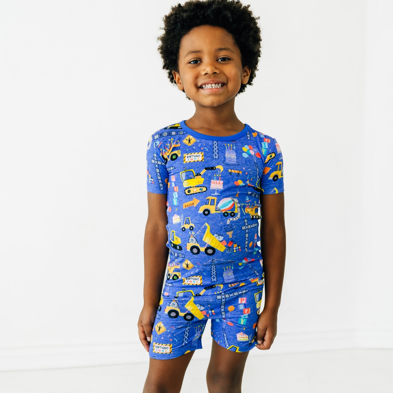 Close up of a child wearing a Birthday Builders Two-Piece Short Sleeve & Shorts Pajama Set