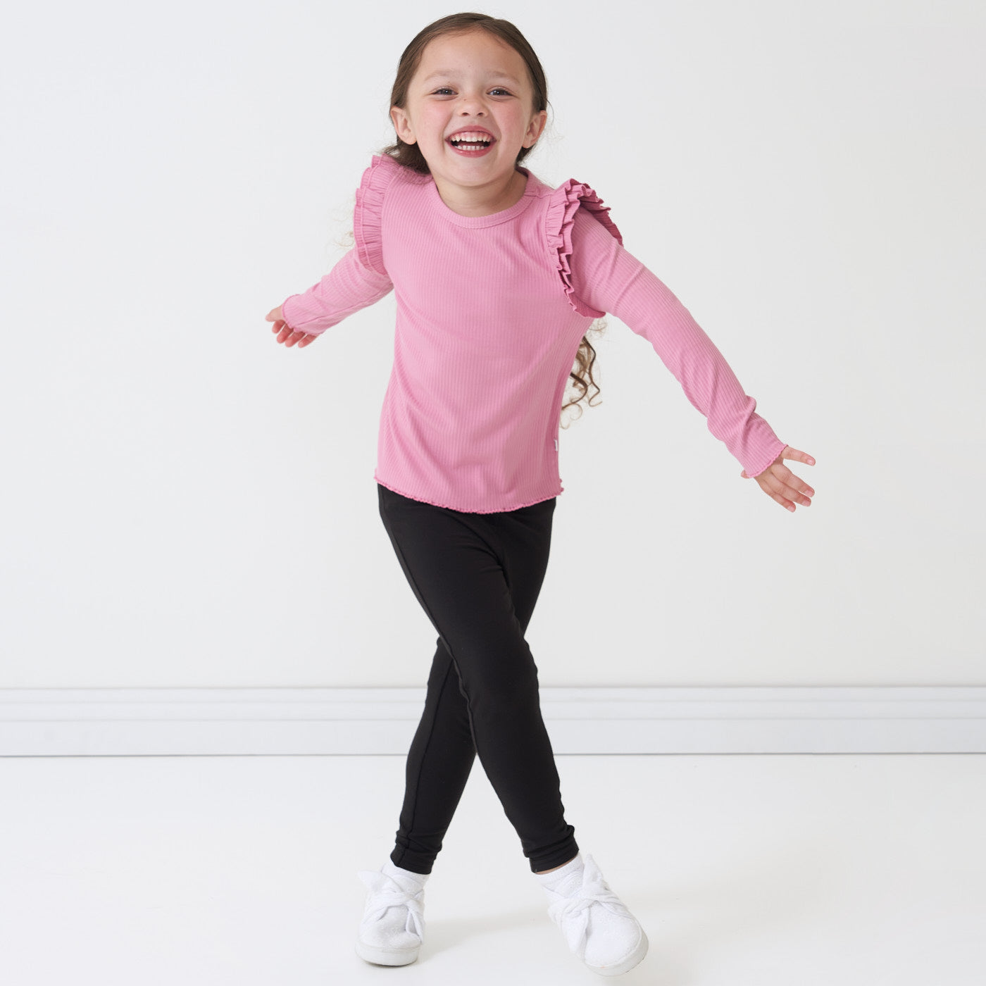 Child wearing Black cozy leggings and a coordinating Garden Rose flutter lettuce tee