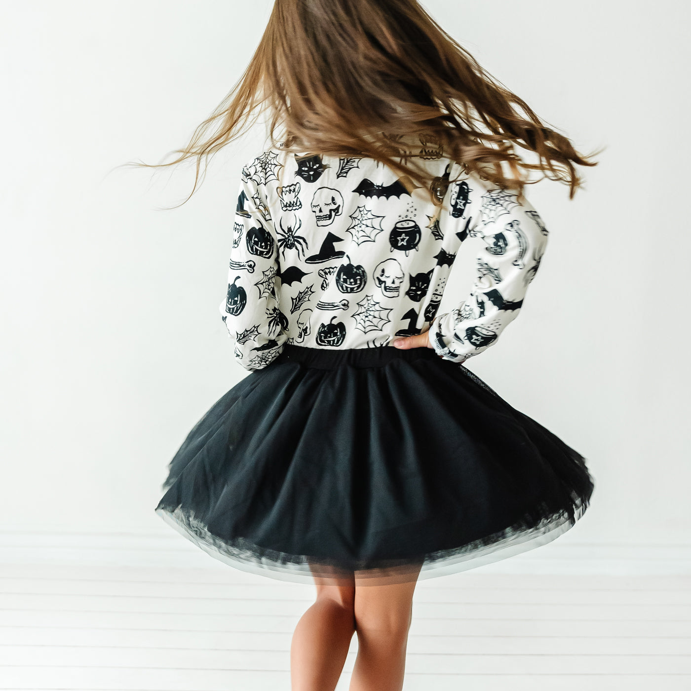 Child twirling wearing a Witches Brew pocket tee paired with a Black bamboo viscose lined tutu