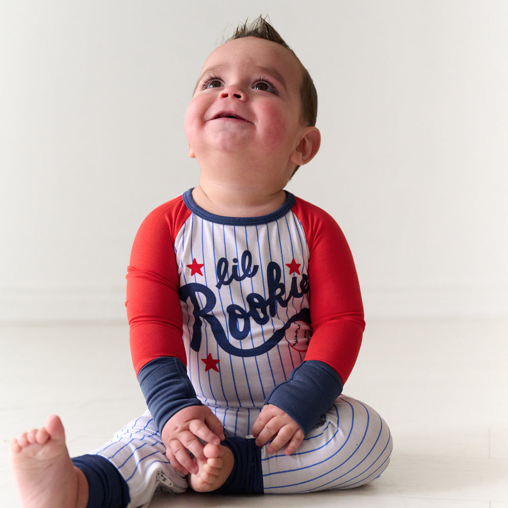 Child sitting and looking up wearing a Blue Lil Rookie Crescent Zippy