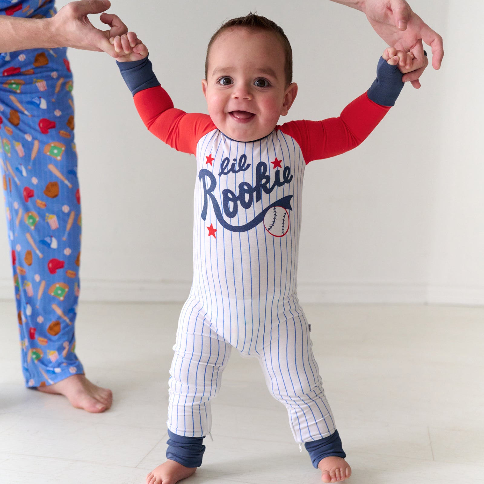 Child being held up by their father wearing a Blue Lil Rookie Crescent Zippy