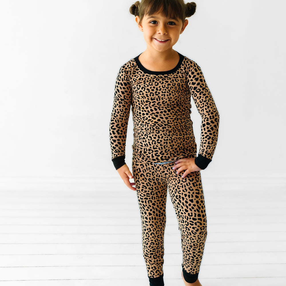Child with a hand on her hip wearing a Classic Leopard two piece pajama set