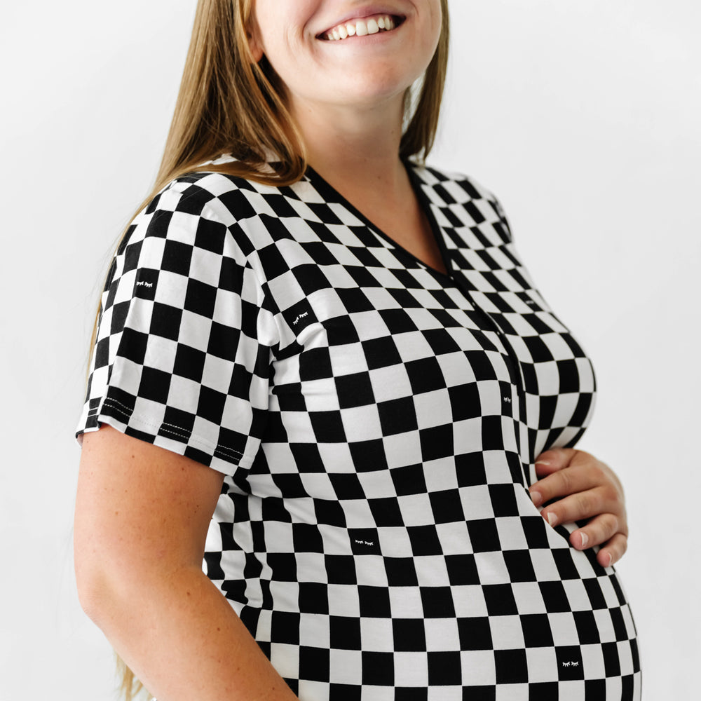 Click to see full screen - profile view of a woman holding her baby bump wearing a Cool Checks printed women's pajama top