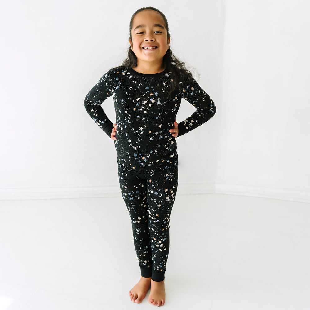 Child with her hands on her hips wearing a Counting Stars printed two piece pajama set