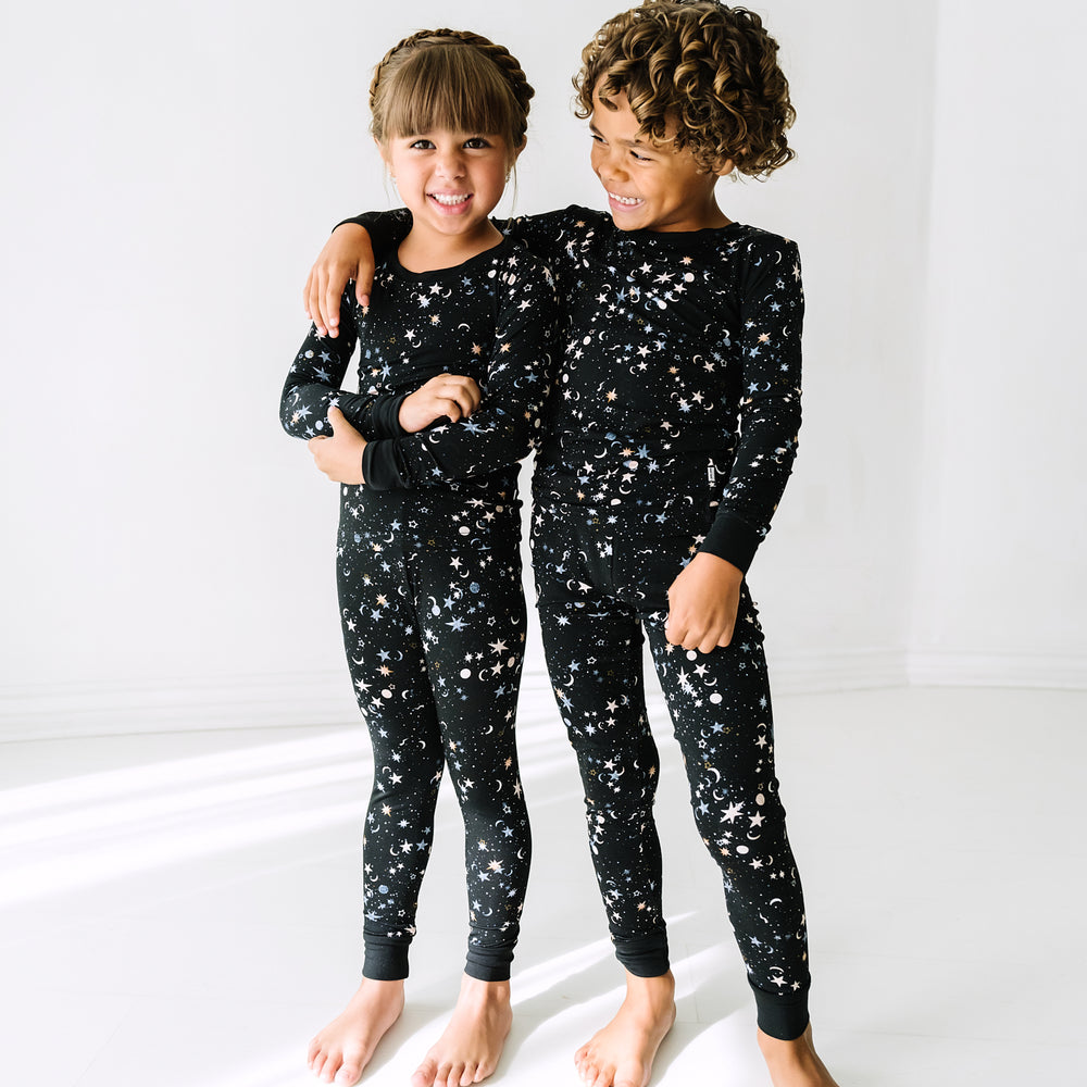 Two children wearing matching Counting Stars printed two piece pajama sets