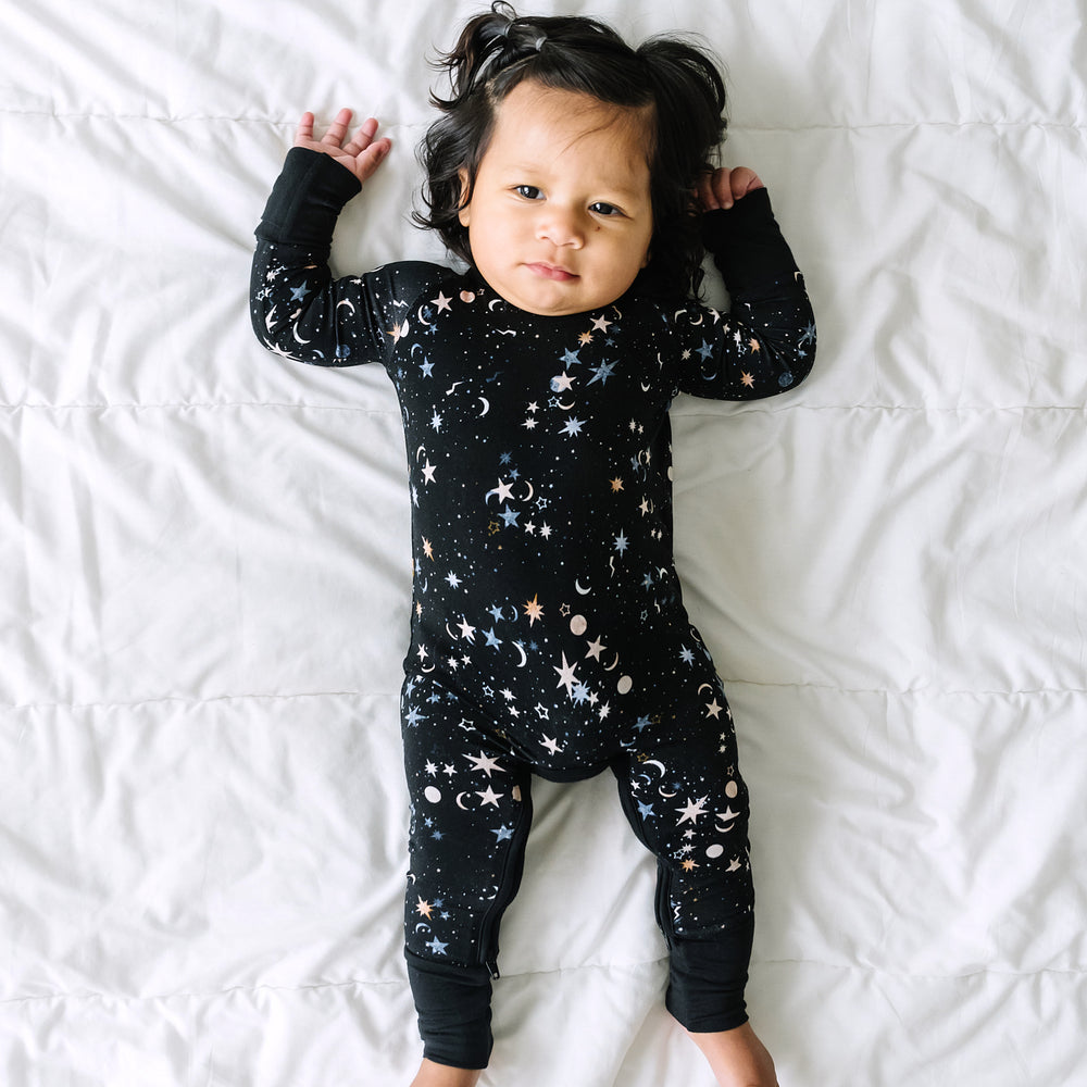 Child laying on a blanket wearing a Counting Stars printed crescent zippy