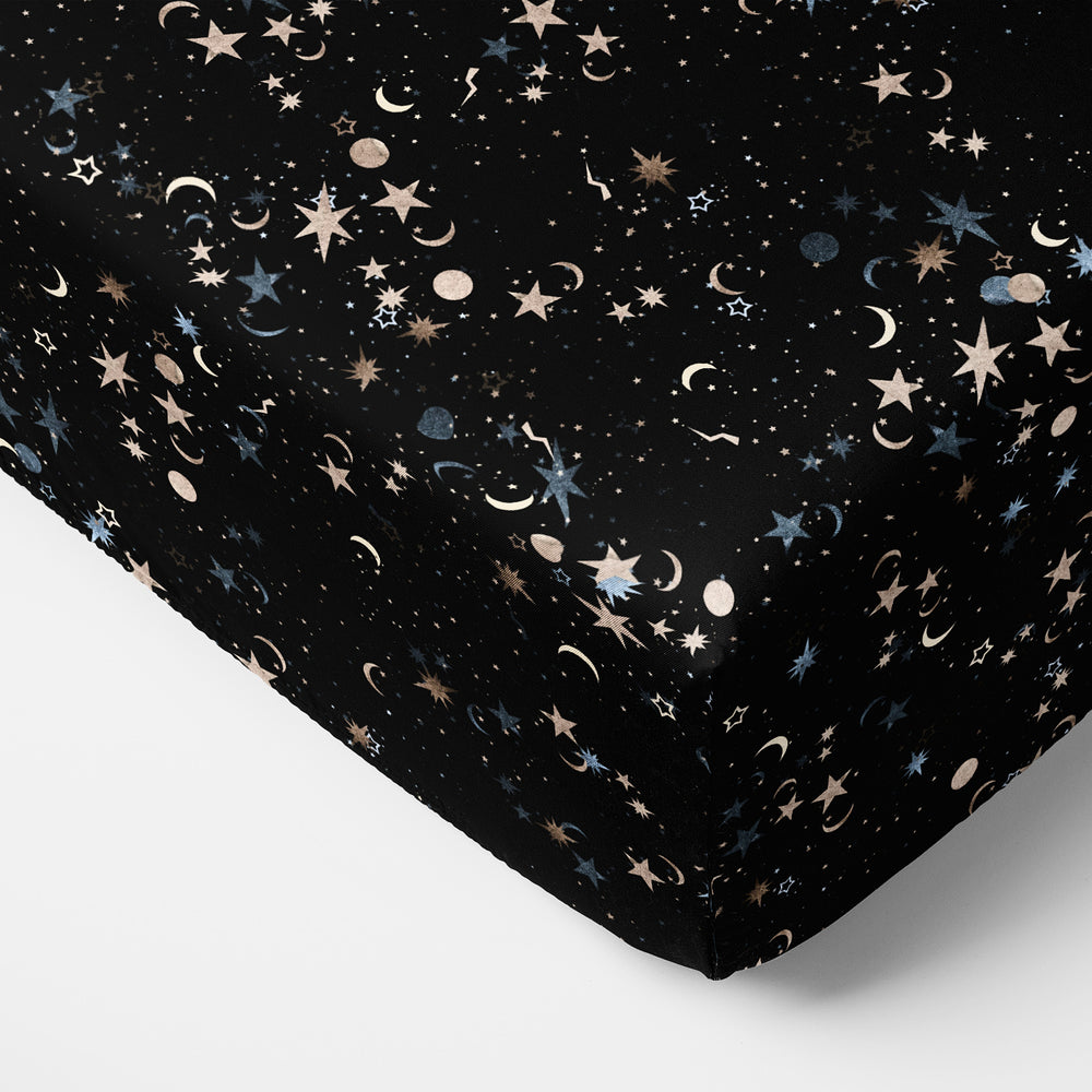 Close up image of a mattress with a Counting Stars printed fitted crib sheet