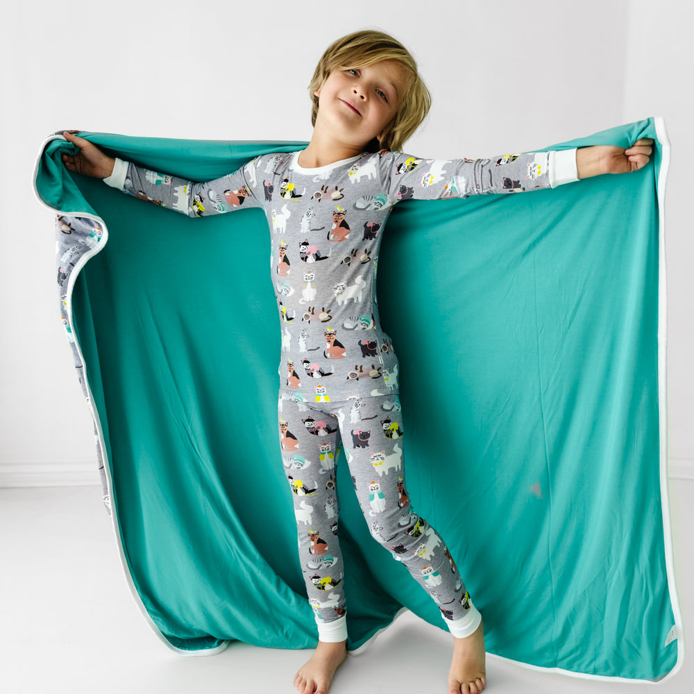 Alternate image of a child with a Cozy Cats large cloud blanket around their shoulders showing the solid color backing